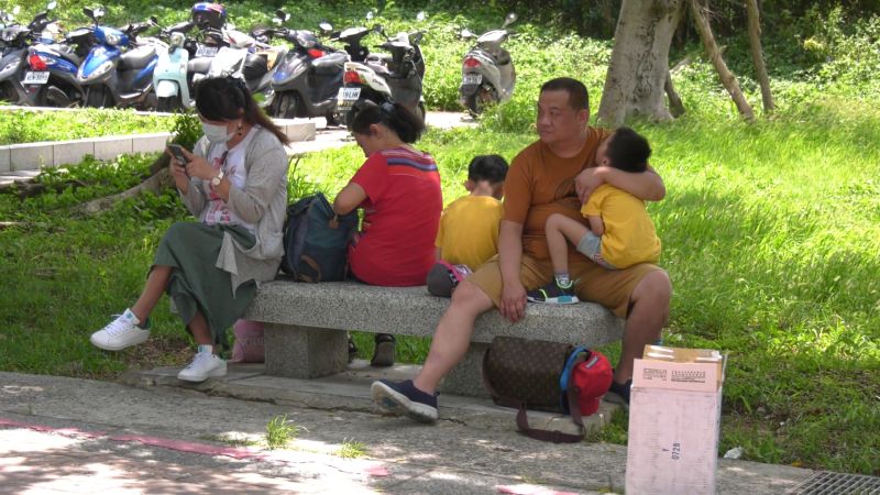 ▲爸爸抱著小朋友在太武山下苦苦等待，一臉無奈。(圖/記者蔡若喬攝)