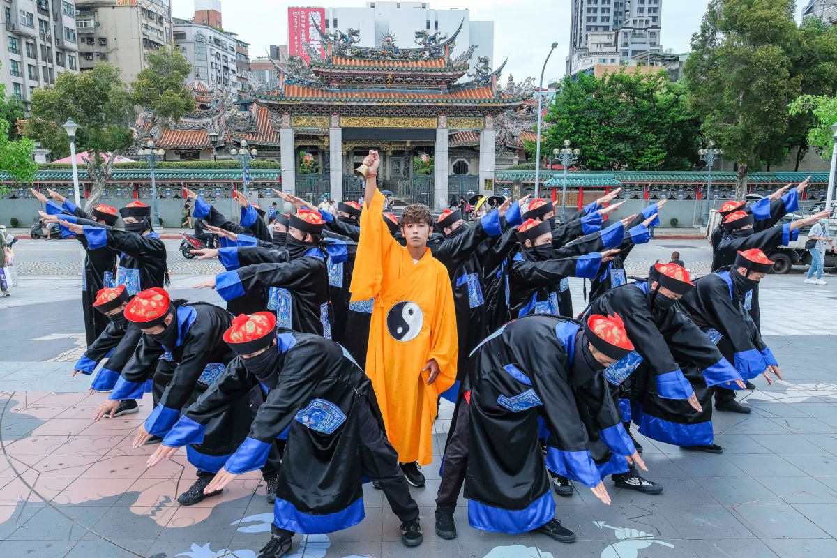 ▲鼓鼓（穿黃袍者）打扮成道士，率領20位扮成殭屍的舞者，快閃台北街頭。（圖／相信音樂提供）