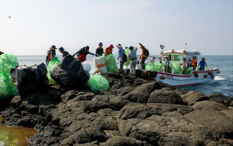 ▲特戰志工將揀拾完的垃圾運至岸邊，再利用東吉當地居民的管筏，接駁至遊艇上。（圖／海管處提供）