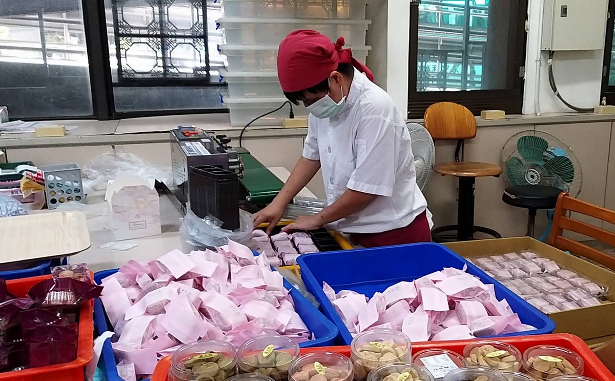 ▲屏東身障庇護工場製作土鳳梨酥包裝封口及裝盒。（圖／屏東市勝利之家提供）