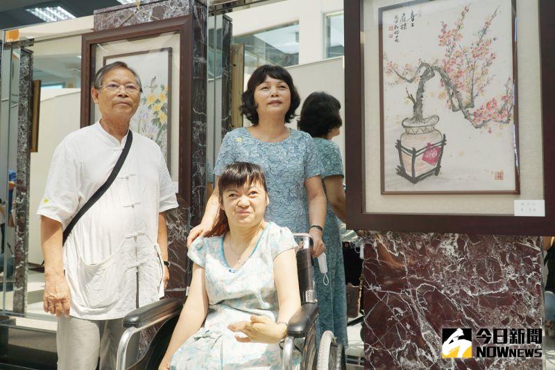 ▲楊淑怡(前)在大葉大學圖書館展出她用腳創作的國畫。(圖/記者陳雅芳攝)