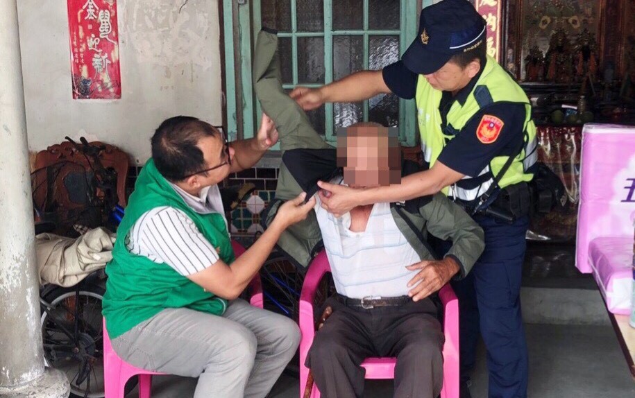 ▲張榮發基金會及員警為右手肌腱斷裂的洪民穿上外套。（圖／記者蘇榮泉攝，2020.10.07）