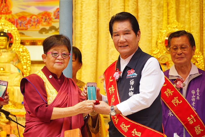 ▲行動佛殿108站嘉義梅山，佛定放生日及觀音菩薩吉祥日法會，執行長陳和慧(左)致贈綠度母墜子給梅山鄉長林俊謀(右)，感謝公私協力關懷弱勢。（圖／世界佛教正心會提供）
