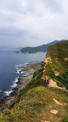 ▲小徑環繞著海岬，向左望可看到龍洞鎮(照片背景)，也就是龍洞岩場的所在地。The trail wraps around both sides of the cape, with the eastern coast looking out towards the neighboring town ofLongdong(龍洞) (seen here in the background)–home of the Dragon Caves (龍洞岩場).(Courtesy of Gregory Thorpe Badrena)