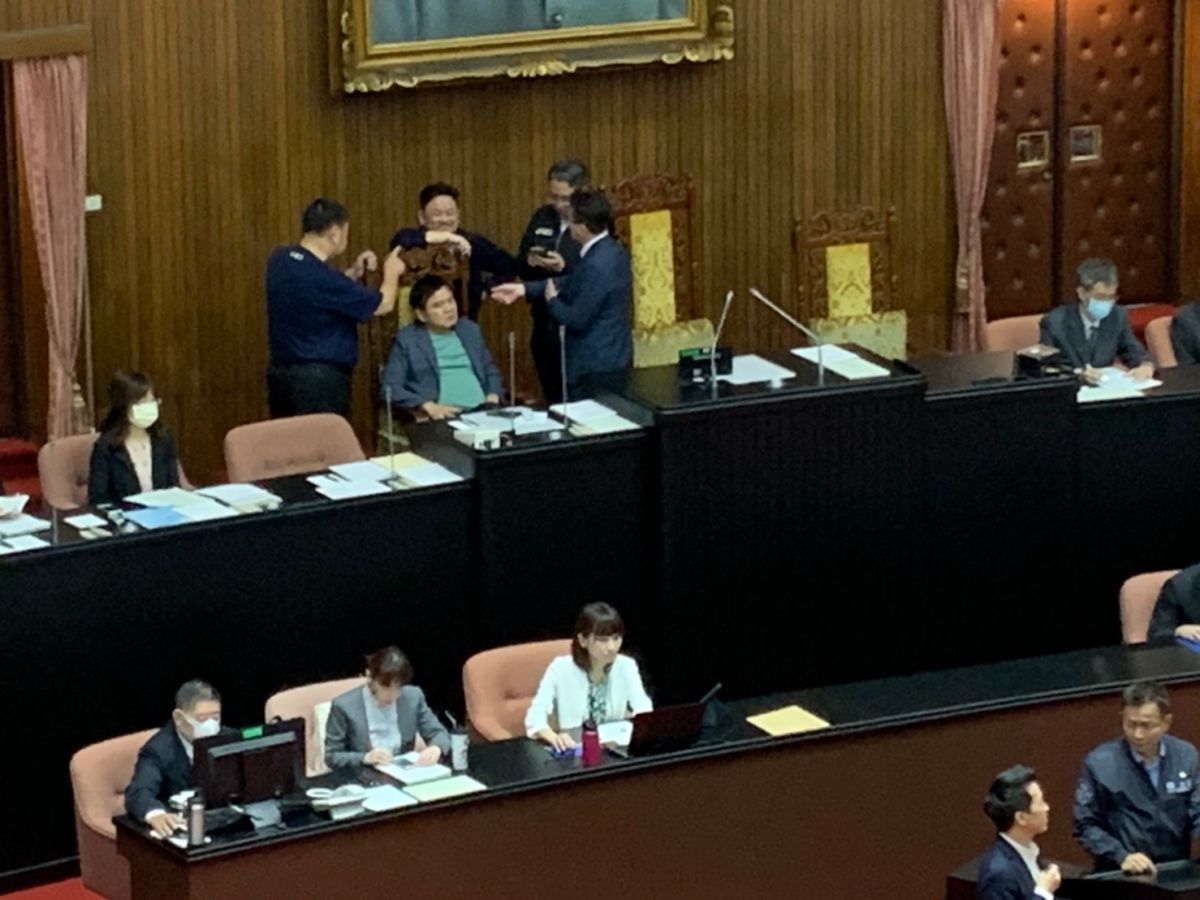 ▲藍綠兩黨幹部在議場主席台僵持，大約討論了20分鐘，民進黨團幹部才願意讓出位子。　（圖／記者吳承翰攝）