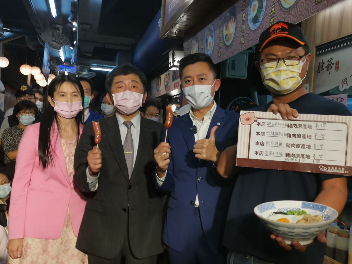 ▲陳時中等人到訪肆爺炒泡麵等店家，視察了解店家豬肉產地標示狀況，他並大口吃起店家肆爺炒泡麵特製的高粱豬肉香腸。(圖/記者金祐妤攝,109.11.18）