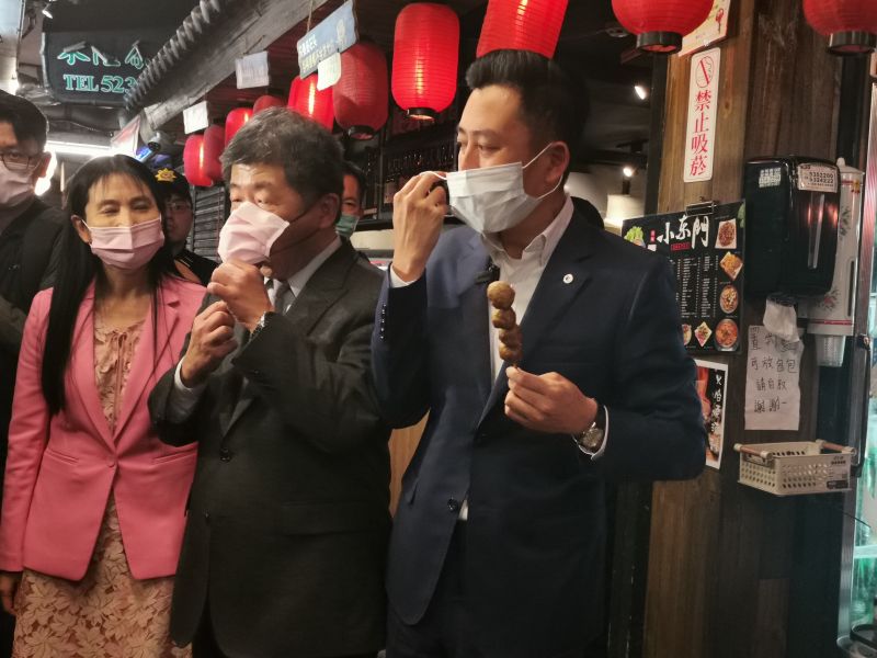 ▲陳時中拉開口罩品嘗使用台灣國產豬肉製成的新竹貢丸串燒。(圖/記者金祐妤攝,109.11.18)