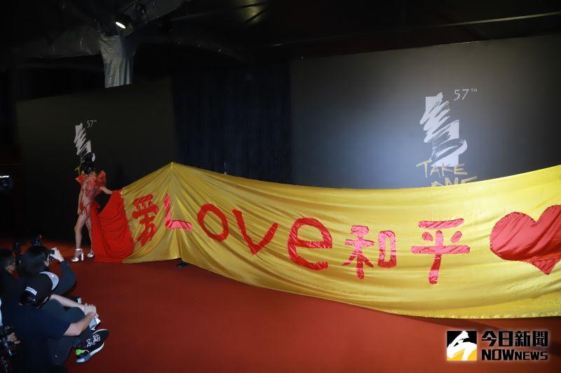 ▲白靈身後用黃色布料寫下「愛LOVE和平」。(圖/NOWnews影像中心)