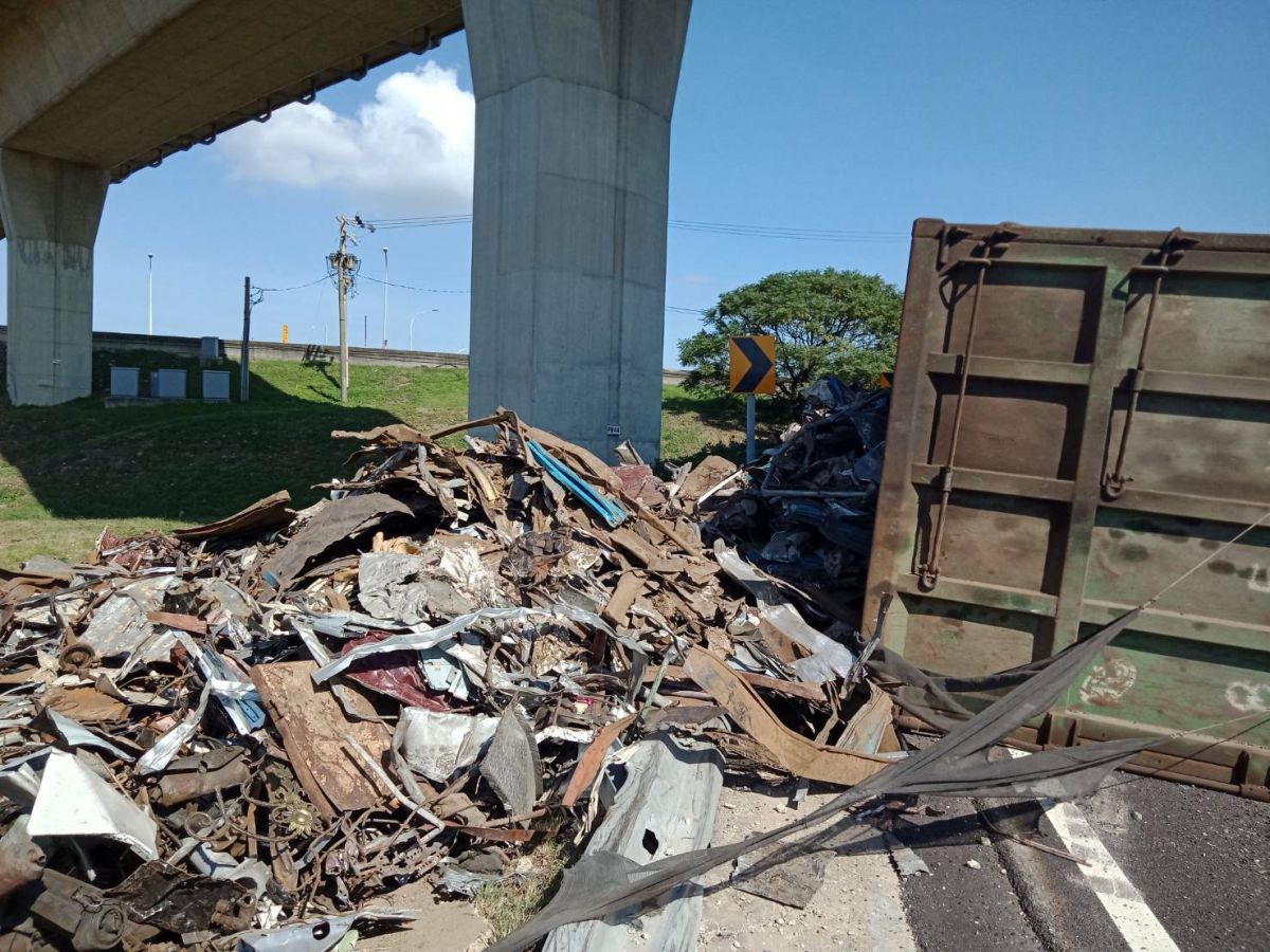 ▲大貨車行經國道2號大園交流道彎道發生翻覆意外，車上的金屬廢料散落一地。（圖／記者李春台翻攝）