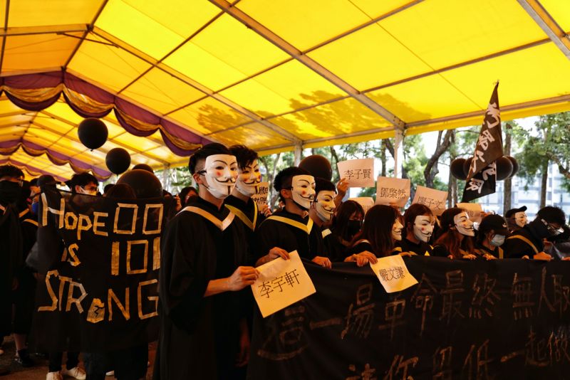▲香港中文大學11月19日校內有約百名學生穿著學士袍遊行示威。（圖／翻攝自《香港01》）