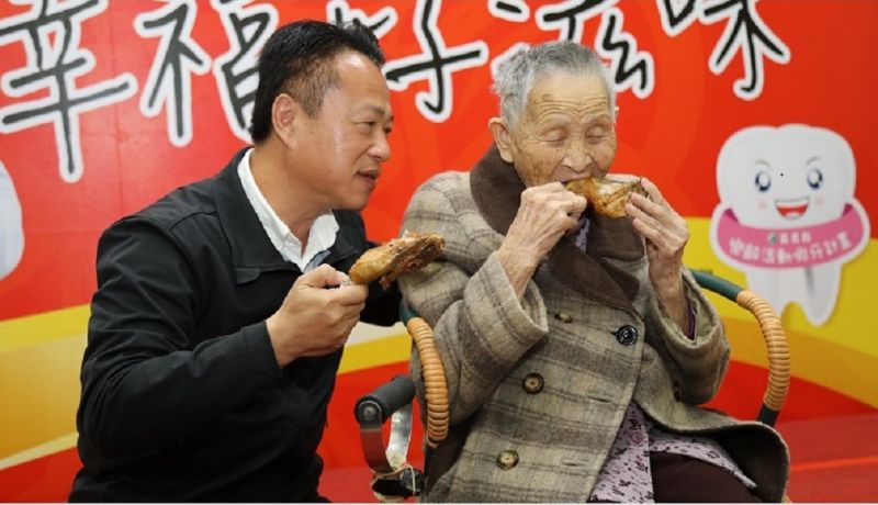 106歲的陳阿嬤因翁章梁縣長(左)上任後的換假牙政策，目前已能大口啃雞腿。(圖／嘉義縣政府提供）
