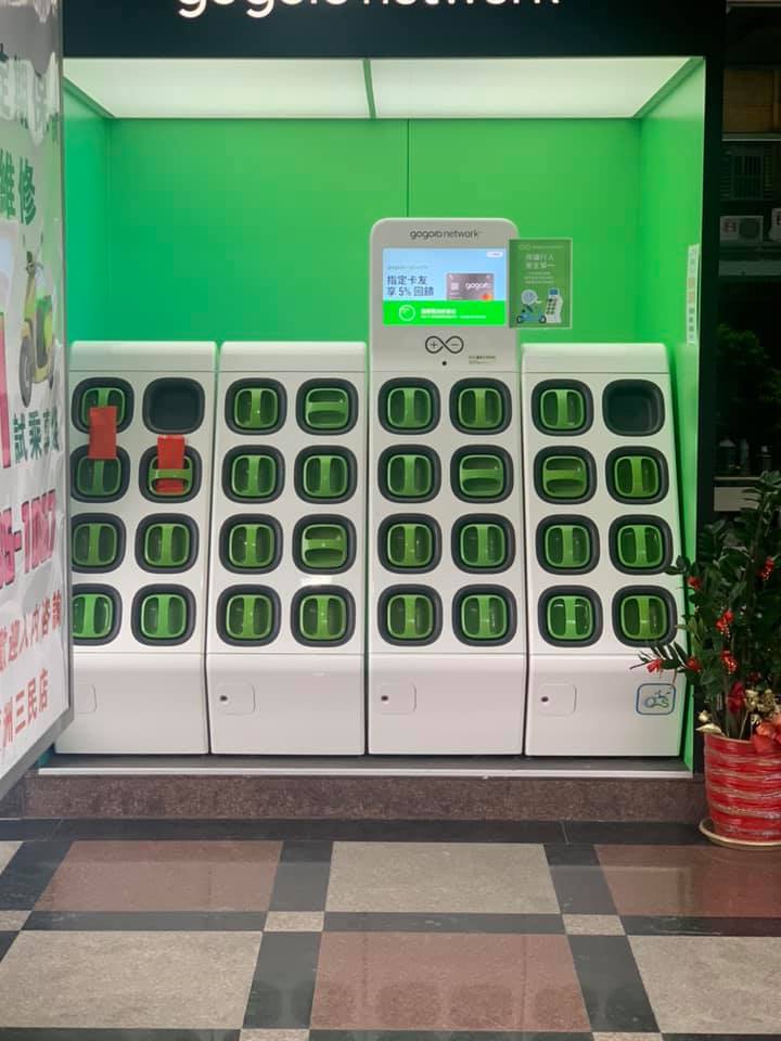 ▲在一個幾乎擺滿電池的Gogoro充電站中,最左邊的兩排電動機車電池充電座上方,卡著「兩個意義不明的直向紅包」。(圖/翻攝自臉書社團《路上觀察學院》)