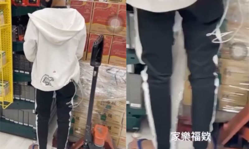 ▲影片中身穿白色外套,黑運動褲的男子,在貨架旁小便。(圖/翻攝自《Dcard》)