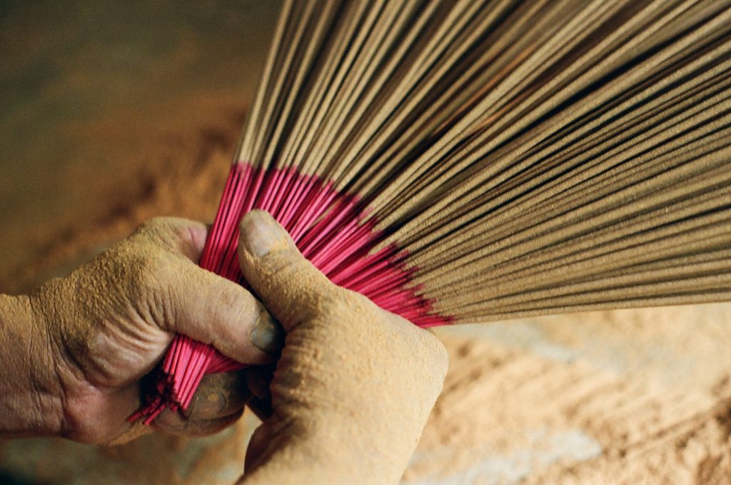 「沾黏仔、扭轉香支、再沾中藥粉，最後抖去多餘的粉」一連串的步驟十分繁複，沒有多餘的動作。（圖／剝皮寮歷史街區城西營運中心提供／特展平面攝影賴彥茹、徐佳鈴）