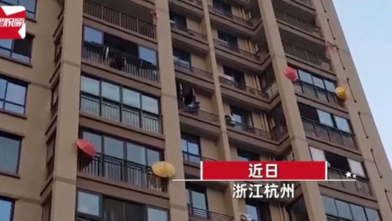 ▲近日中國有網友發現雖然是晴天，卻有許多大樓住戶高掛雨傘。（圖／翻攝自星視頻微博）