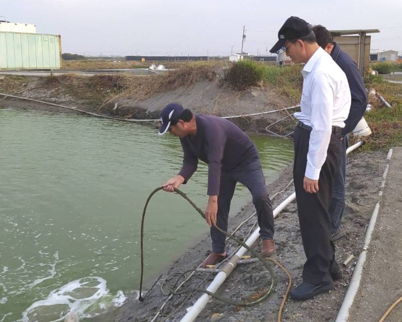 ▲高雄市海洋局局長黃登福(右)到漁業養殖區瞭解漁民使用鼓風機產生熱氣注入魚塭禦寒的情形。(圖/記者黃守作攝,2021.01.07)