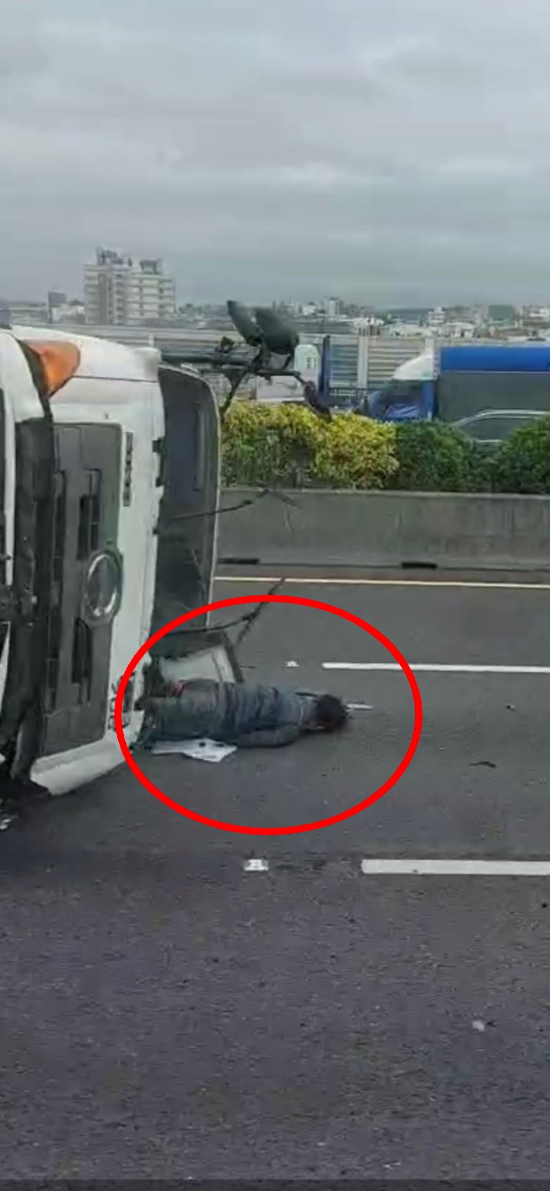 ▲聯結車側翻國道,占用中間、內側車道,車底不斷冒煙,駕駛自行爬出車外中線位置。(圖/記者陳雅芳翻攝,2021.01.07)