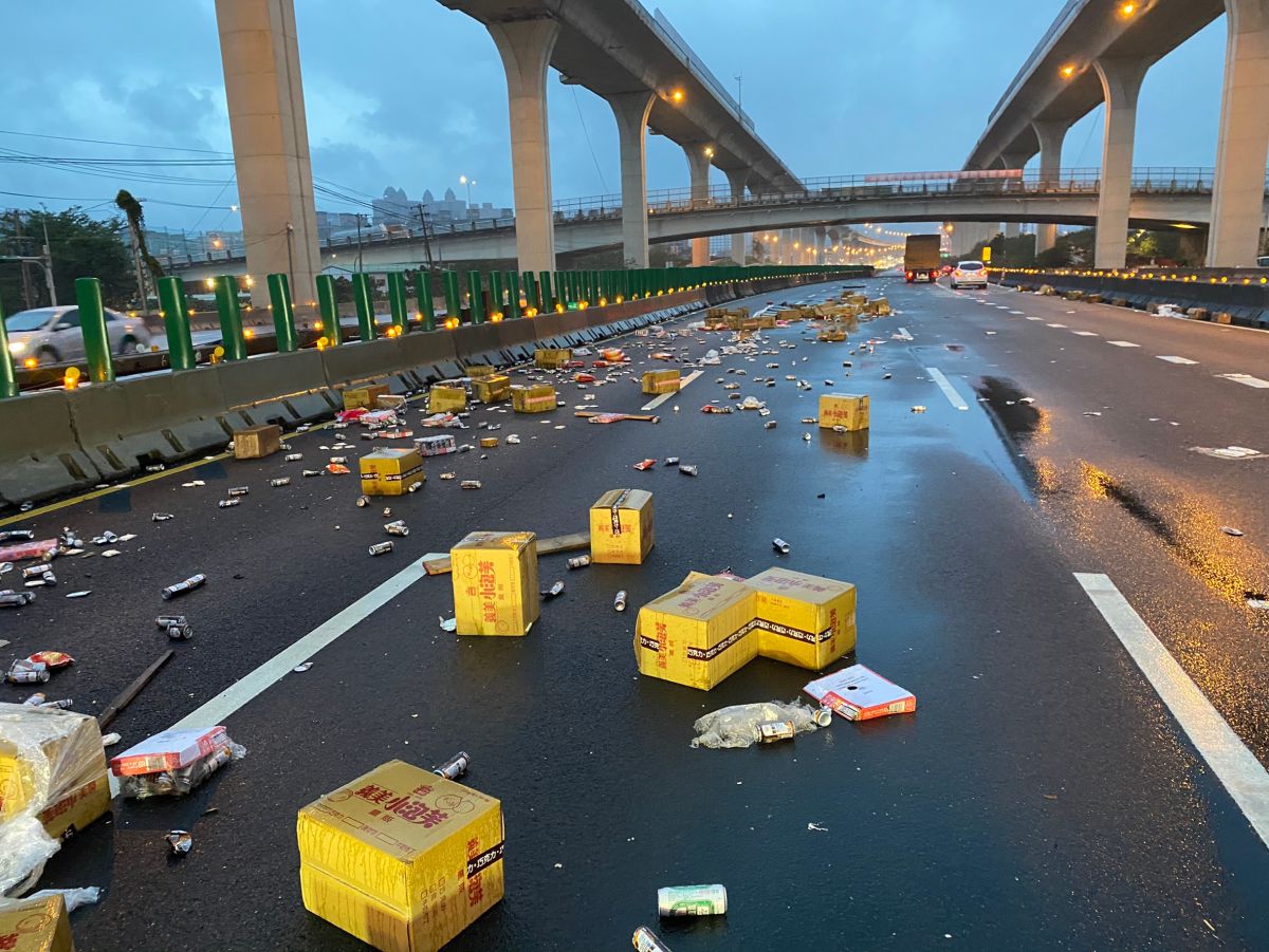 ▲大貨車疑似自撞護欄導致車輛翻覆，導致內側三車道散落許多掉落物，現場僅外側一車道可供通行（圖／國道警察大隊提供）