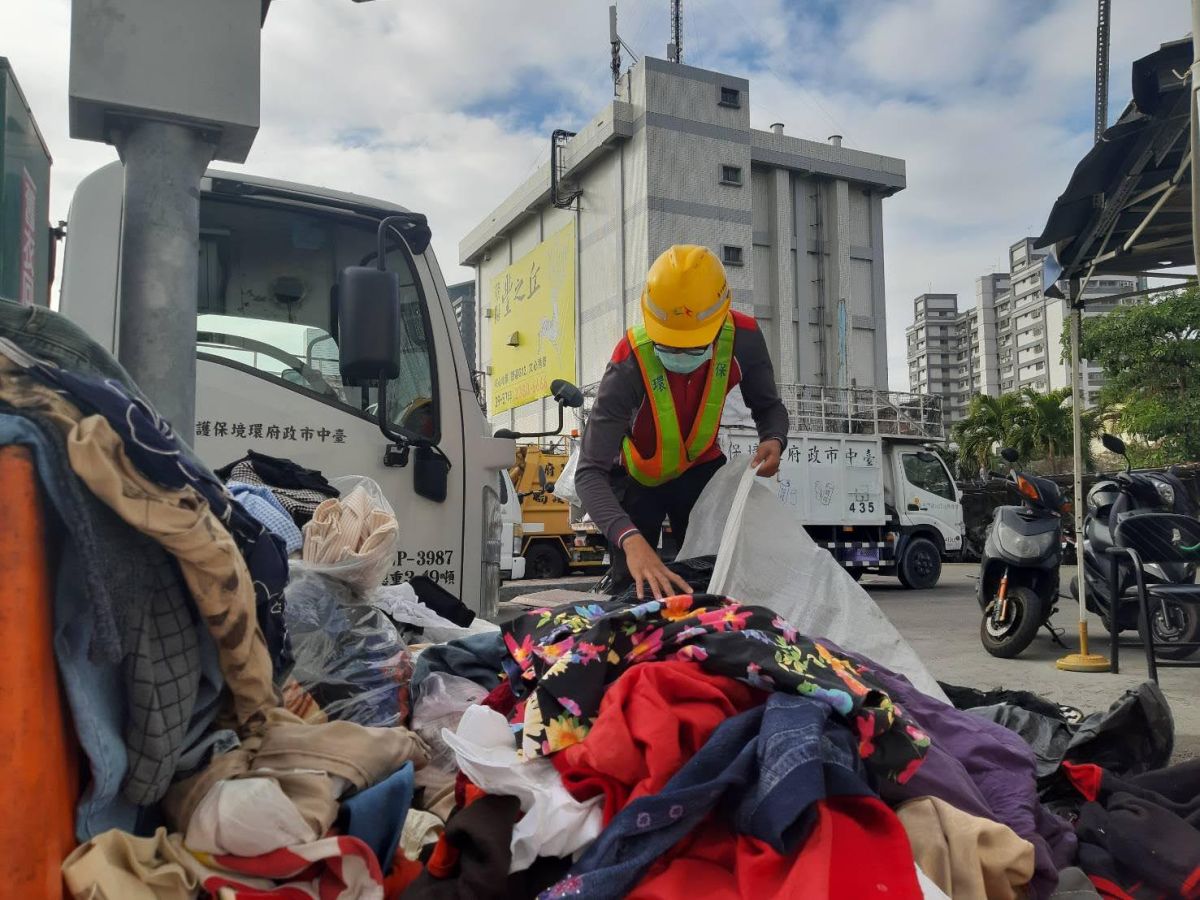 ▲南屯區清潔隊員黃祈隆整理回收舊衣物時，發現一包舊衣袋內有紅包袋及不同面額的鈔票(圖／環保局提供2021.2.1)