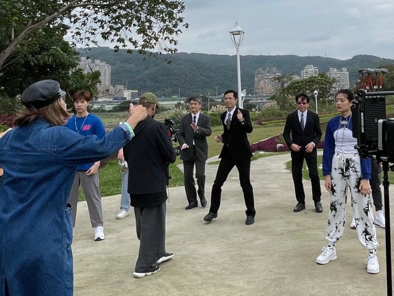 ▲「五股新冪境綠地公園」也成為拍攝場景,環保局程大維局長(右2)、城鄉局黃國峰)及農業局李玟局長(右4)賣力唱跳,宣傳五股垃圾山整頓成果。(圖/新北市政府提供)