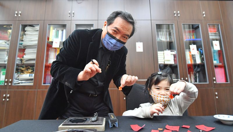 ▲政委羅秉成教小朋友寫書法。(圖/行政院提估)