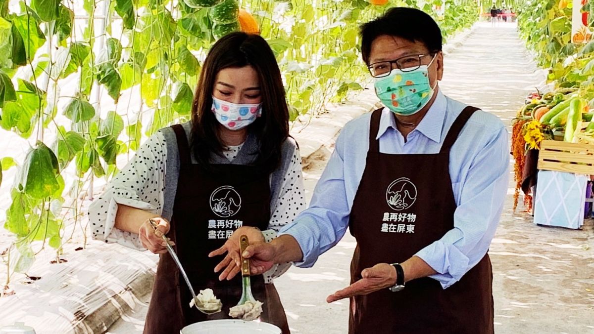 ▲潘孟安與邵庭在瓜棚下宣傳熱博園區內展售的屏東農漁特產品。（圖／屏東縣政府提供）