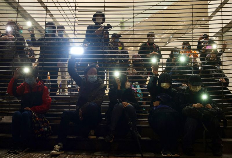 ▲香港民眾聚集在西九龍法院外聲援被捕的47人，入夜後民眾用手機手電筒持續聲援。（圖／美聯社／達志影像）