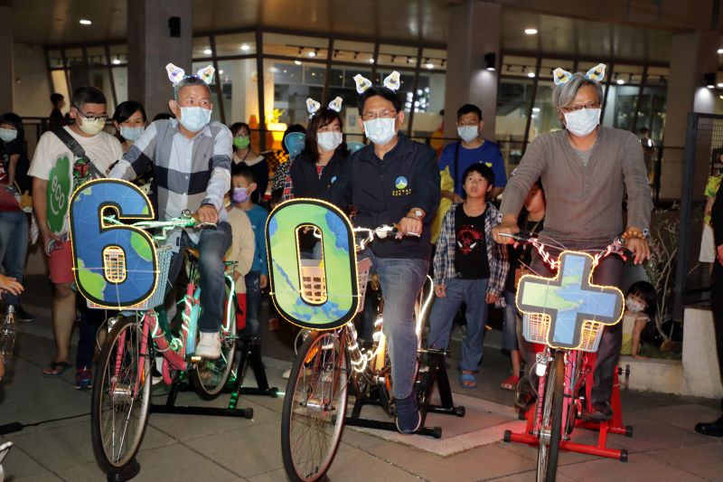 ▲台南市環保局長謝世傑(中)奮力騎著發電腳踏車，當關燈時間一到，靠著腳踏車的電力，讓四周燈泡發出光亮（圖／記者林怡孜攝，2021,03,27）