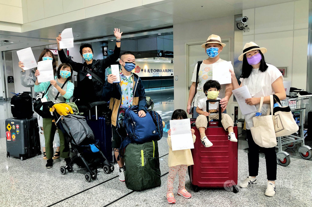 ▲帛琉旅遊泡泡次發團4日下午將出發，除了10名團客，另有3名商務散客同機，13人的核酸檢測都是陰性。旅客順利取得核酸檢測陰性報告，開心展示檢測結果。中央社記者吳睿騏桃園機場攝 110年4月4日