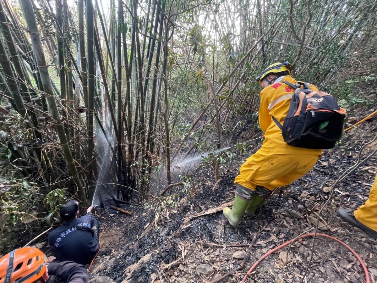▲消防隊員拉起水線在斜坡上滅火。（圖／翻攝畫面）