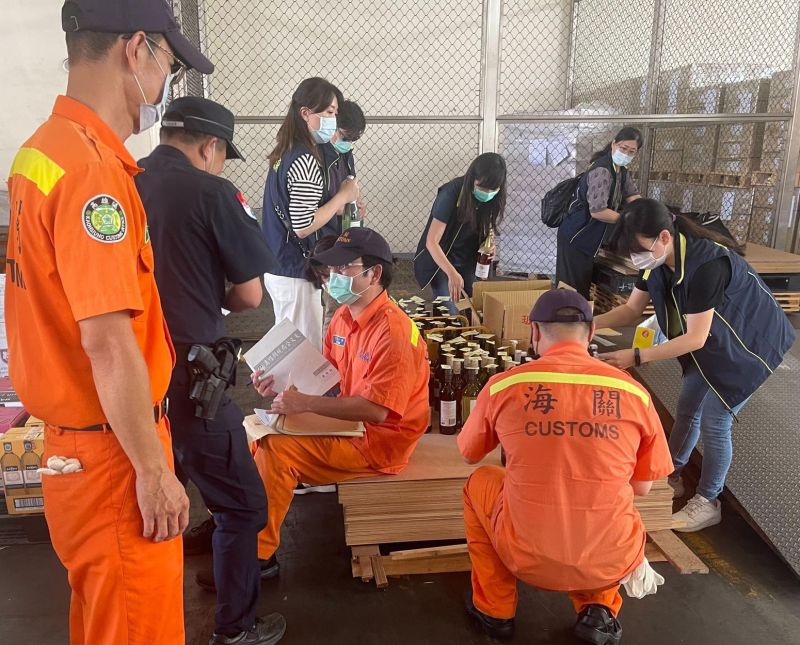 ▲財政部關務署高雄關查獲轉口貨櫃匿藏大批洋酒,海關人員清點洋酒的數量。(圖/記者黃守作攝,2021.04.23)