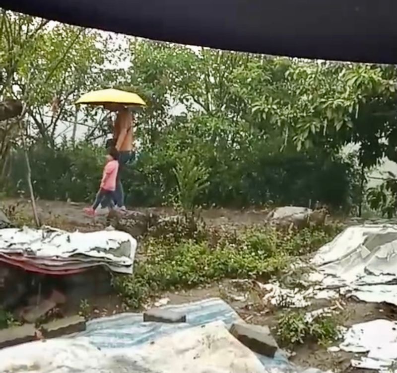 ▲台南楠西區灣丘洪園休閒農場附近路降雨,民眾撐起雨傘(圖/台南市政府提供)