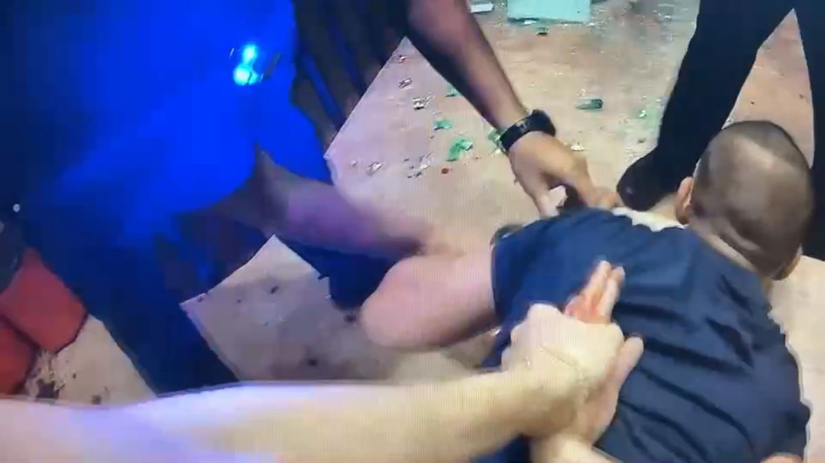 ▲張男酒後在KTV砸店，被警方壓制在桌上，現場仍可見滿地碎玻璃。（圖／翻攝畫面）