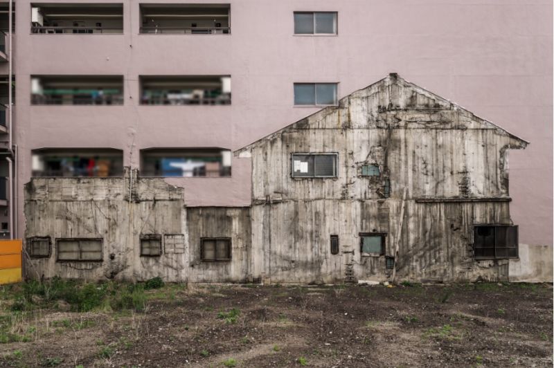 ▲一位日本攝影師發現從在一旁的空地望向房屋會看見當年的「鬼屋」依舊烙印在隔壁建築牆上。(圖/擷取自@JIYUKENKYU_jp/推特)