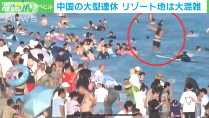 ▲遊客像是下水餃一般擠在海裡頭,還有民眾不顧人潮自顧自玩衝浪。(圖/翻攝自ANN