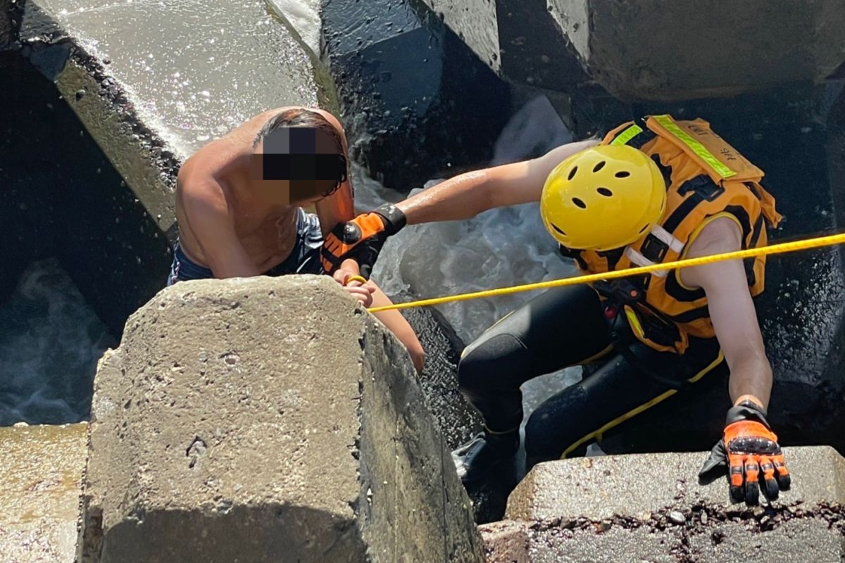 ▲林男下水游泳遭到海流沖走，最後被卡在消波塊中受困，幸好被及時趕到的海巡及消防人員成功救援上岸。（圖／海巡署提供）