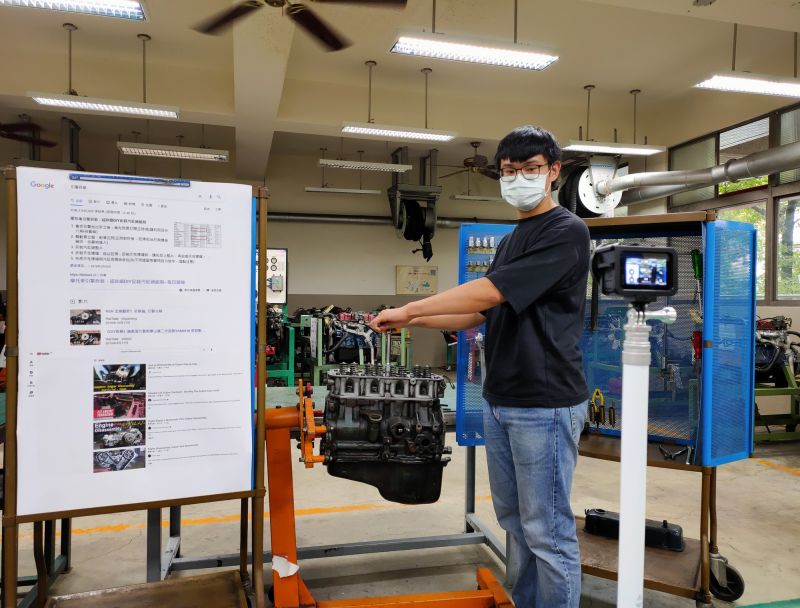 ▲泰山高中汽車科邵勸誠老師在汽車工廠,推出摩托車引擎與工具箱,對著鏡頭一一講解。(圖/新北市政府教育局提供)