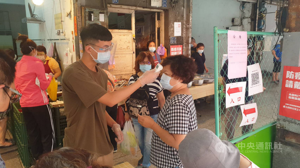 ▲基隆市信義市場因有確診者到此處採買，市府13日宣布這處市場停業，經全面消毒23日恢復營業，市府除規劃進出動線並採取實聯制外，也派服務人員協助消費者量體溫及酒精消毒。（圖/中央社）