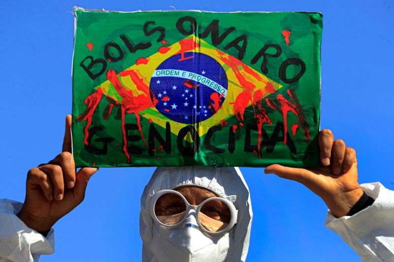 ▲2019冠狀病毒疾病（COVID-19）在南半球的巴西造成逾50萬人死亡，隨著時序進入冬季，呼吸道疾病高發，專家警告新型冠狀病毒大流行可能惡化。圖為手持標語抗議總統波索納洛防疫政策失當的巴西民眾。（圖／美聯社／達志影像）