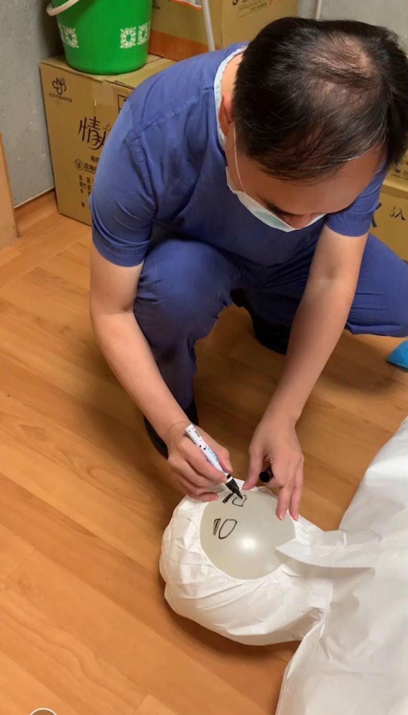 ▲醫護人員細心替填充娃娃畫上五官。(圖/翻攝自慈濟基金會臉書)