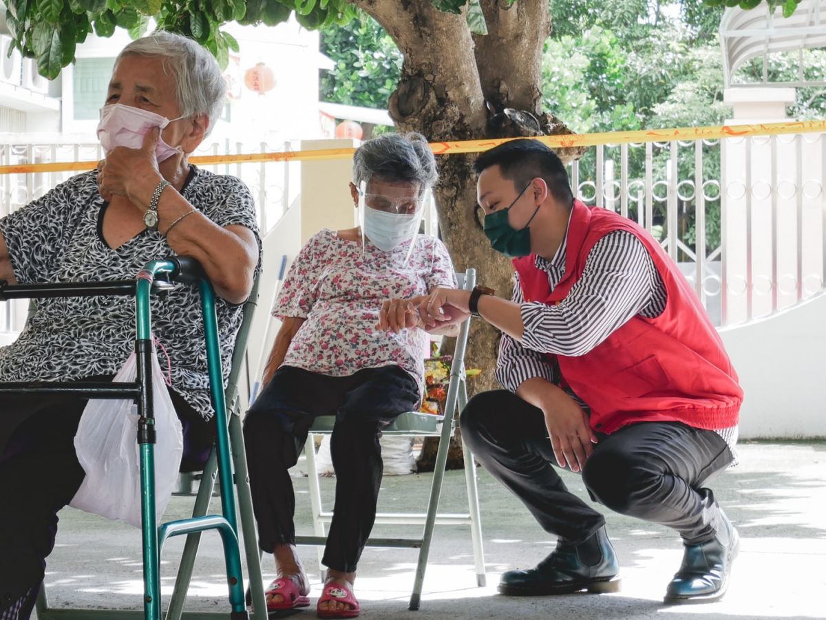 ▲青年局長張以理陪伴現場等候接種的長輩鄉親。（圖／高市府青年局提供）