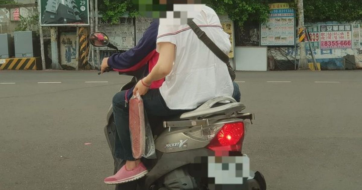 ▲照片中可見當地居民坐著機車，手上豪邁的掛著一條巨大的黑鮪魚，看起來正準備回家煮一頓好料。(圖/擷取自路上觀察學院/臉書)