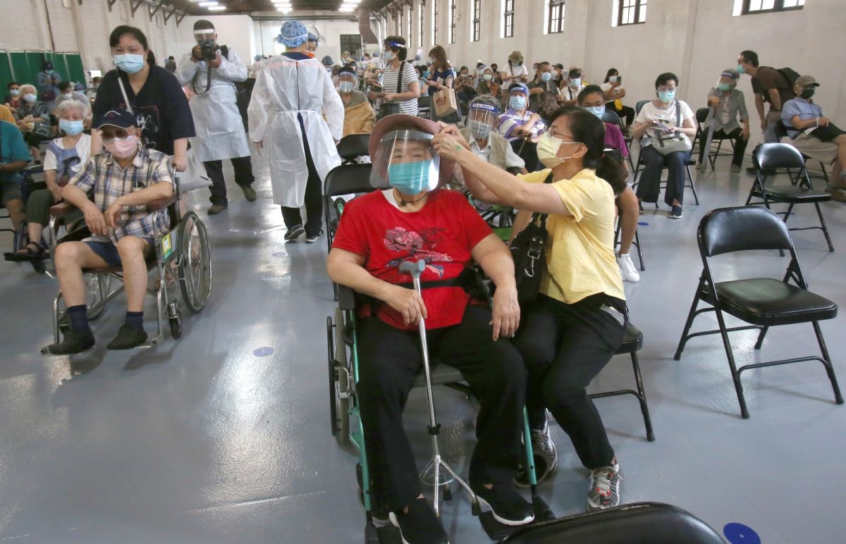 ▲台灣新冠本土疫情爆發，疫苗的供應被高度關注，也衍伸出國產疫苗與國際品牌的選擇問題。圖為近日排隊等接種疫苗的台灣民眾。（圖／美聯社／達志影像）