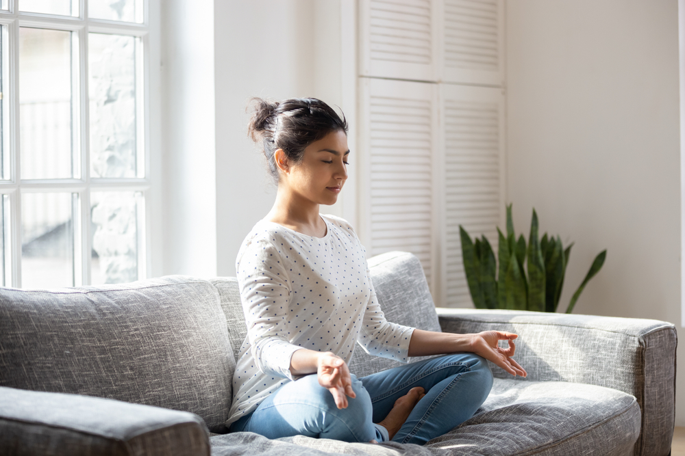 Indian,Female,Sitting,On,Couch,Lotus,Pose,Put,Hands,On