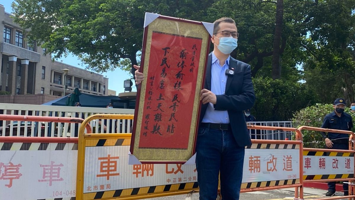 ▲日前名嘴朱學恒因為送花籃至疾管署遭到警方以「妨礙公務」要求到案說明，國民黨台北市議員羅智強1日則到行政院送上同樣字樣的中堂聲援，並表示若違法「以現行犯抓我！」（圖／羅智強辦公室提供）