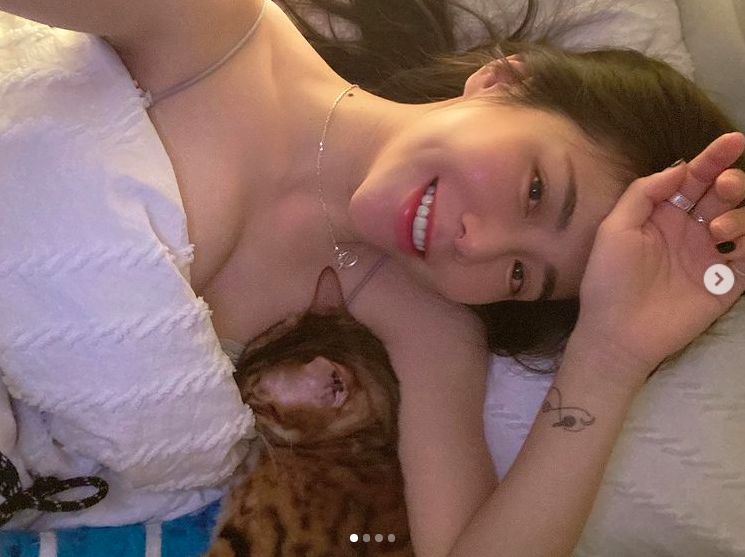 ▲梓梓曬出與愛貓躺在床上的性感照片。（圖／翻攝梓梓IG）