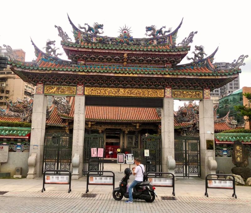 ▲有網友發現台北市萬華龍山寺前有信徒「得來速式」參拜,遵守防疫規定同時也能獲得心靈慰藉。(圖/翻攝自臉書社團「路上觀察學院」)