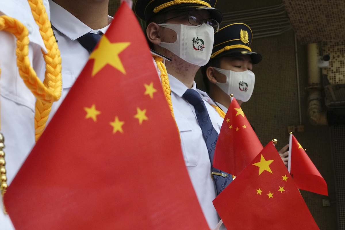 ▲美國政府發布「香港商業警告」被中國外交部形容為「廢紙一張」。 圖為香港回歸24週年，手持五星旗的香港警員。（圖／美聯社／達志影像）