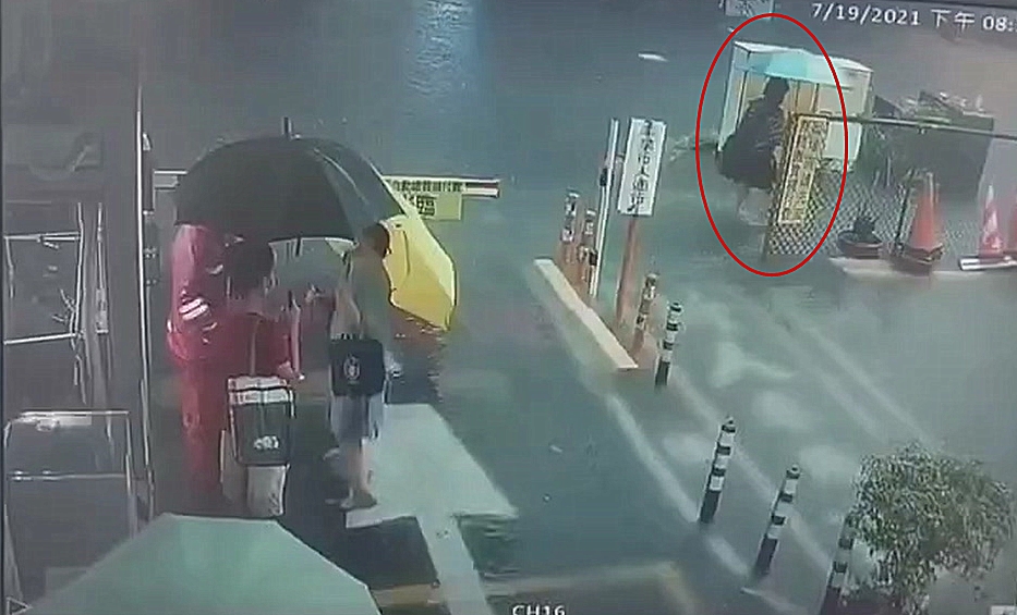 ▲女子涉水行經變電箱及路燈處就突然倒下。（圖／翻攝畫面）