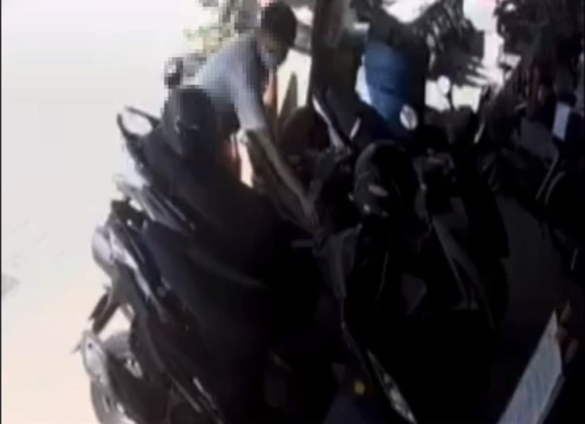 ▲監視器清楚拍下，一名穿著白色T恤的男子，盯上一輛沒拔鑰匙的機車，於是把機車置物箱打開，將置物箱內的包包整個拿走，揚長而去。（圖／新莊分局提供）